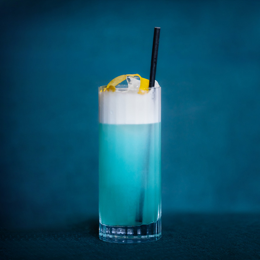 Velvet Hour Cocktail Blue Cocktail with a straw on a dark velvet background