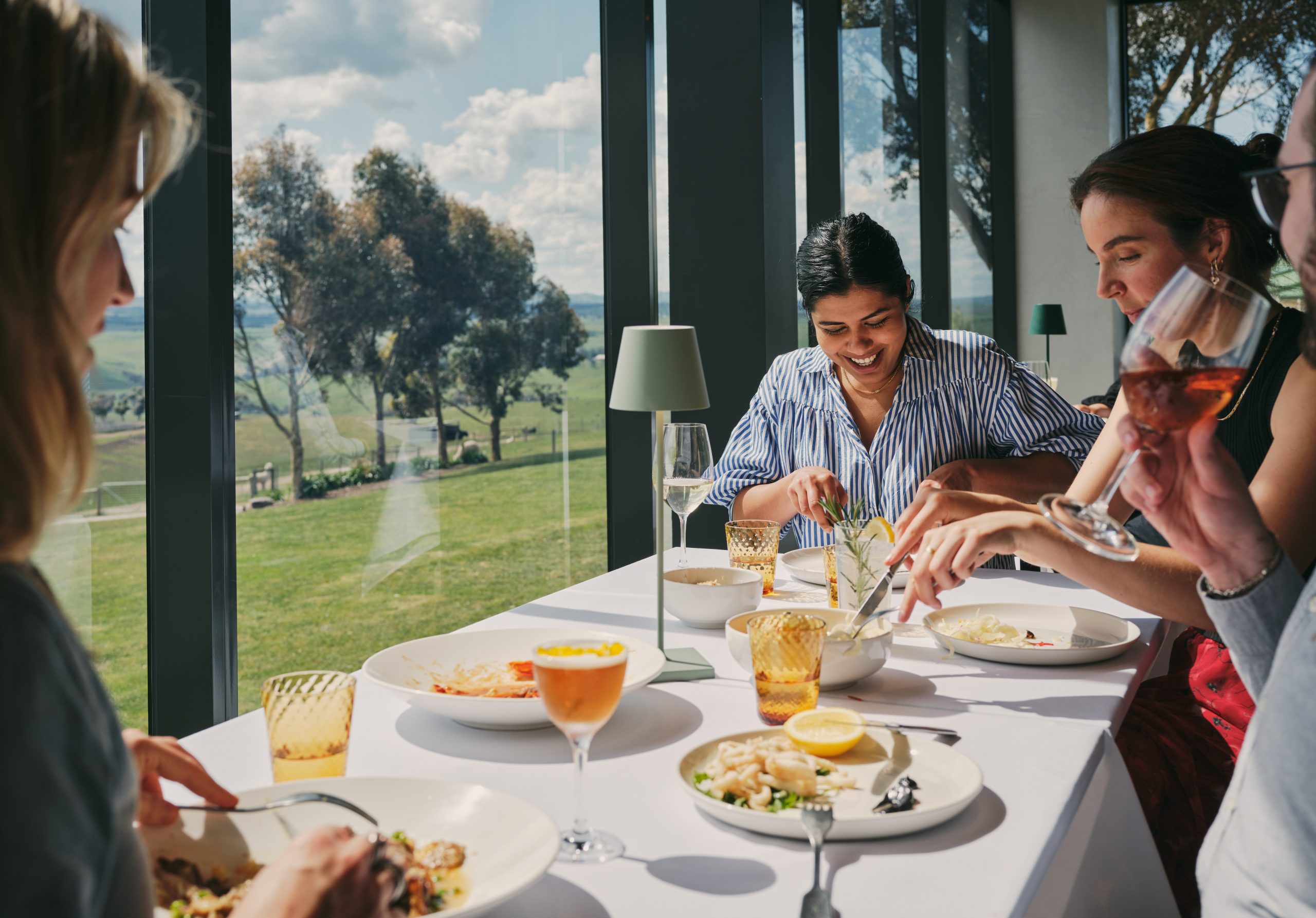 Friends sharing lunch at a window table at La Vètta, hatted in the Good Food Guide 2026