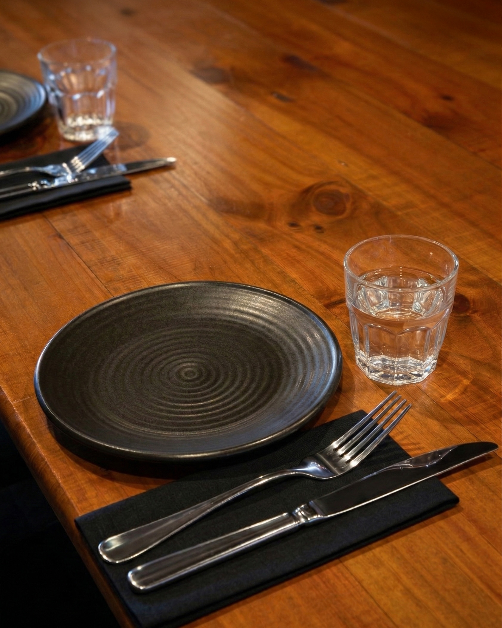 ME_Cucina_PrivateDiningRoom_02 A black elegant plate on a wooden table