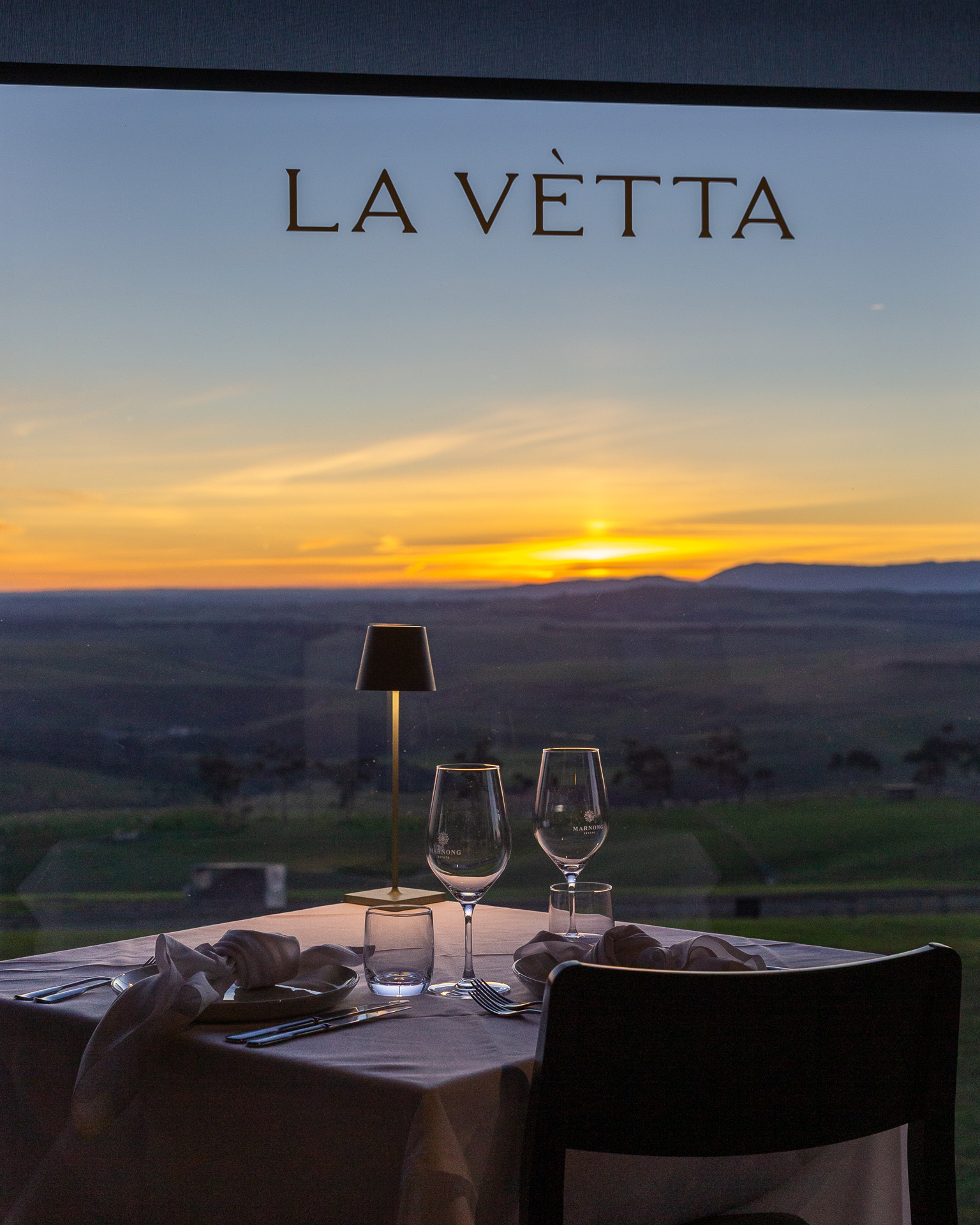 A La Vètta window table set for two as the sun sets over the ranges
